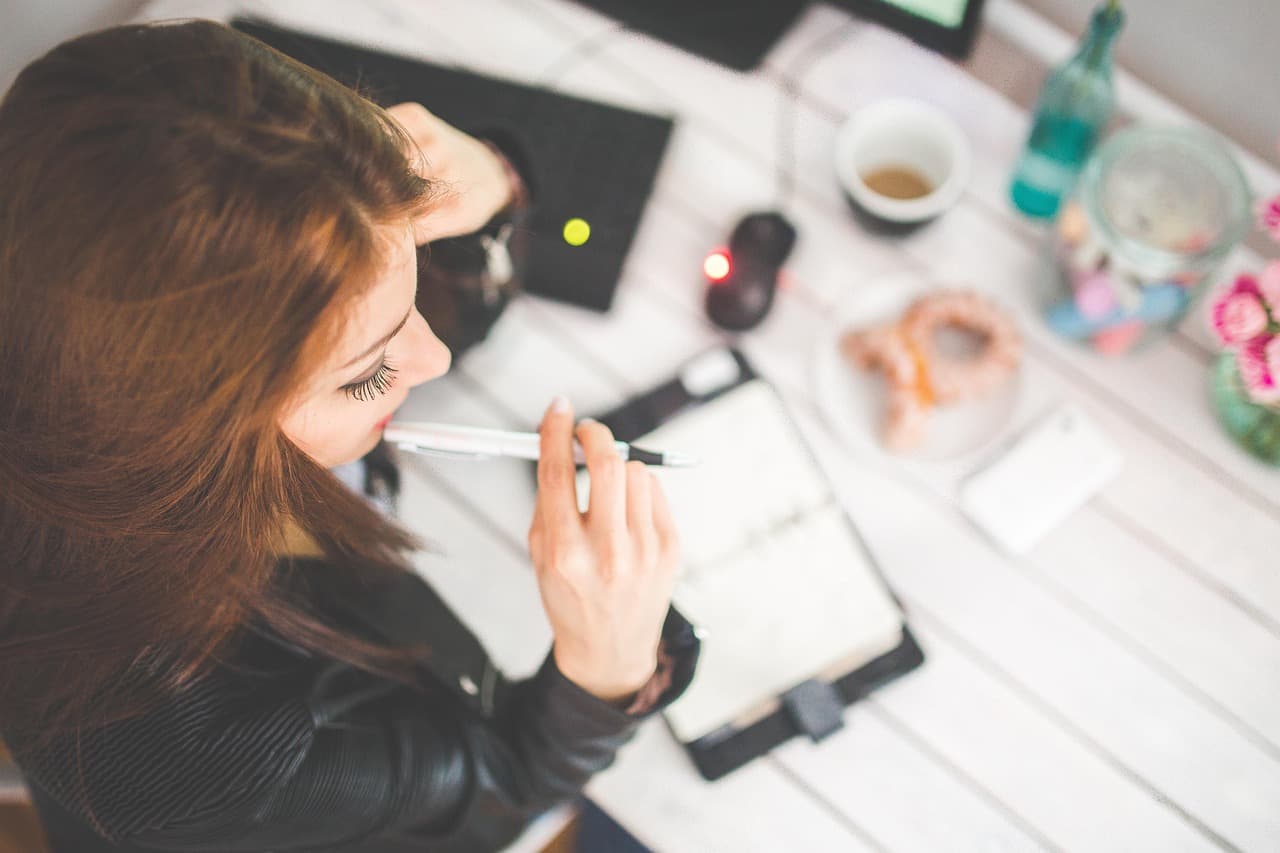 Alguien reflexionando en un escritorio — saber si un VPN merece la pena depende de lo que realmente hagas en línea.