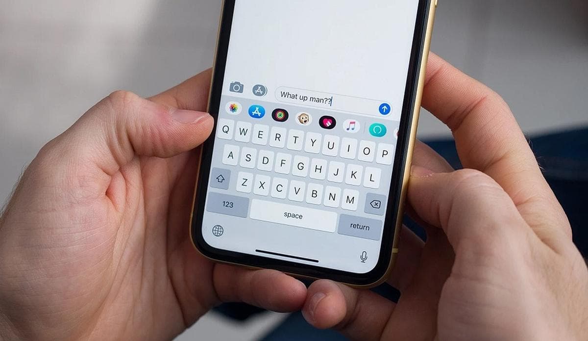 Hands holding a smartphone, typing a message in a chat app