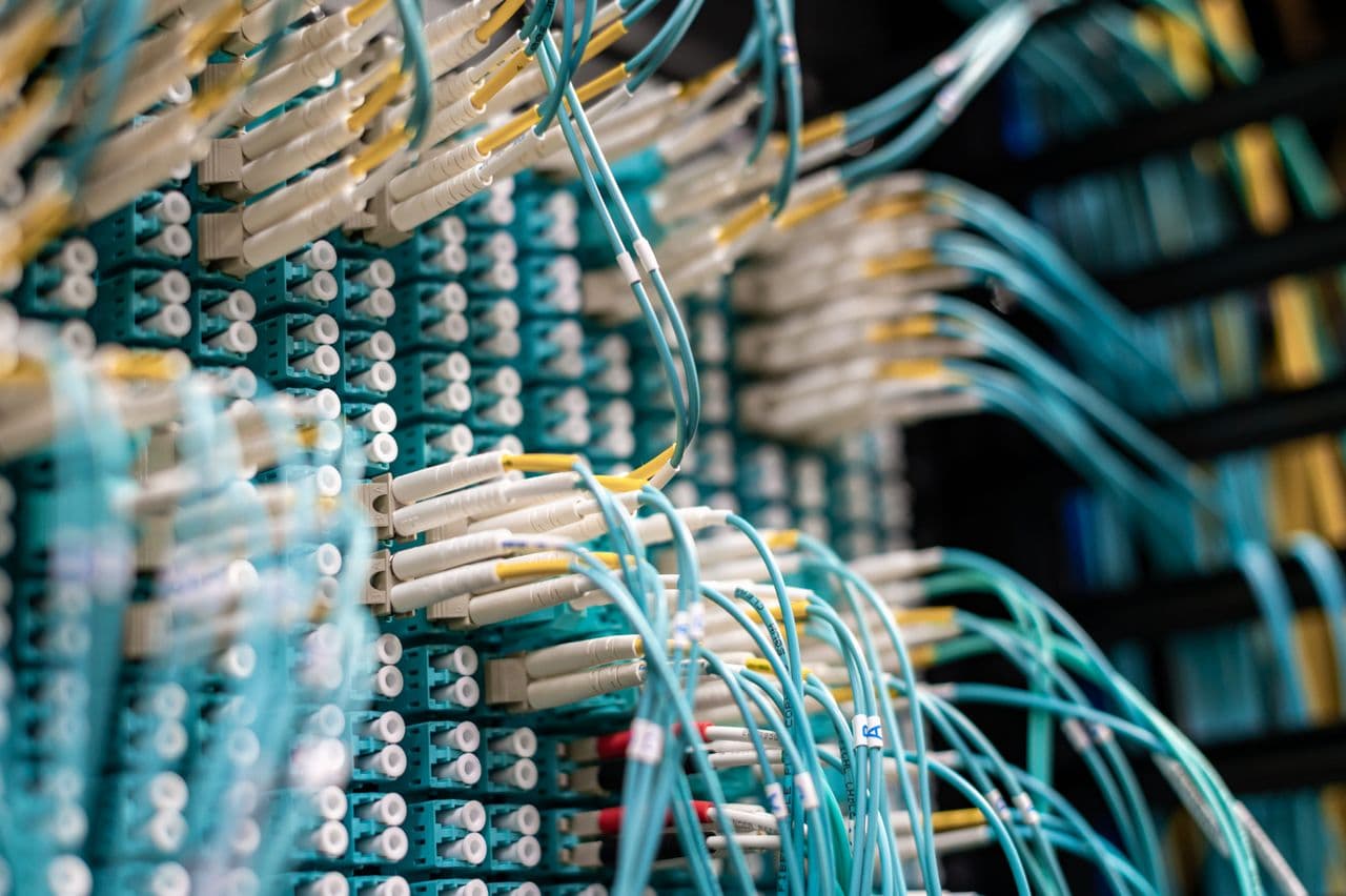 Fiber-optic network cables connected to a patch panel in a data center